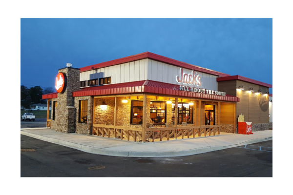 Jack’s restaurant exterior with a red roof, illuminated windows, outdoor seating and a front porch area at dusk.