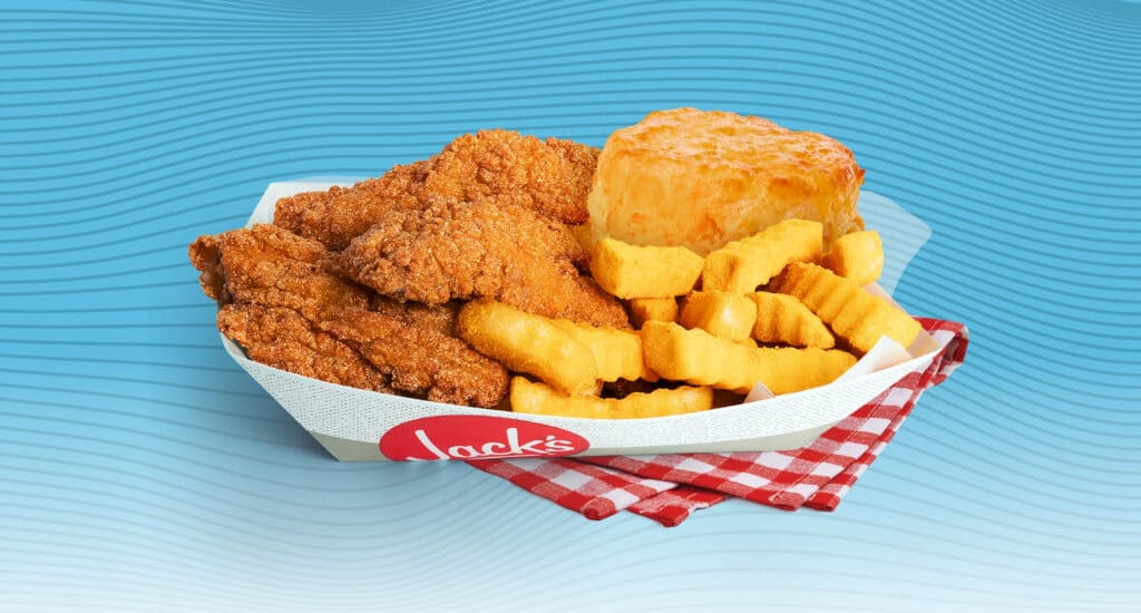 Jack’s Catfish Basket with crispy fried catfish, crinkle cut fries, and a biscuit served in a branded paper tray on a red gingham cloth against a blue wavy background.
