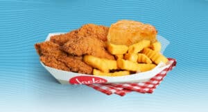Jack’s Catfish Basket with crispy fried catfish, crinkle cut fries, and a biscuit served in a branded paper tray on a red gingham cloth against a blue wavy background.